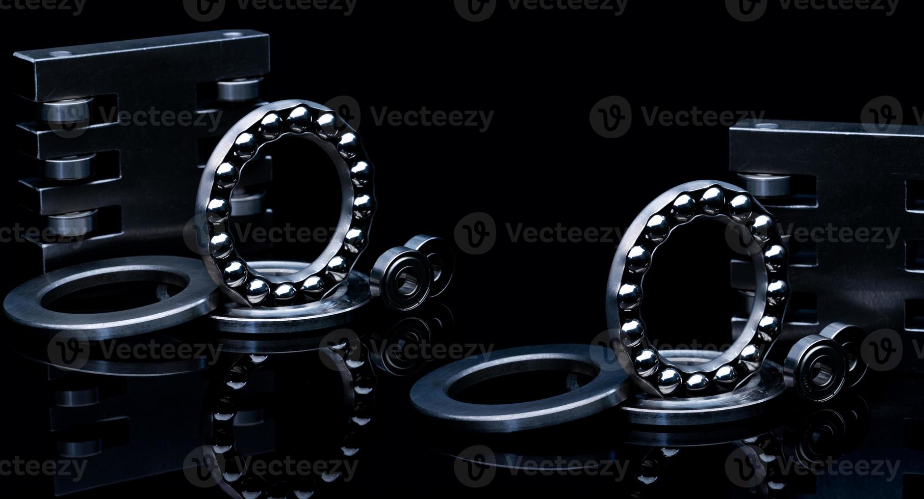 Stainless steel thrust ball bearing and linear bearing. Set of thrust ball bearing and shiny silver ball bearing. Spare parts for roller machine in heavy machinery. Round metal wheel of ball slides. photo