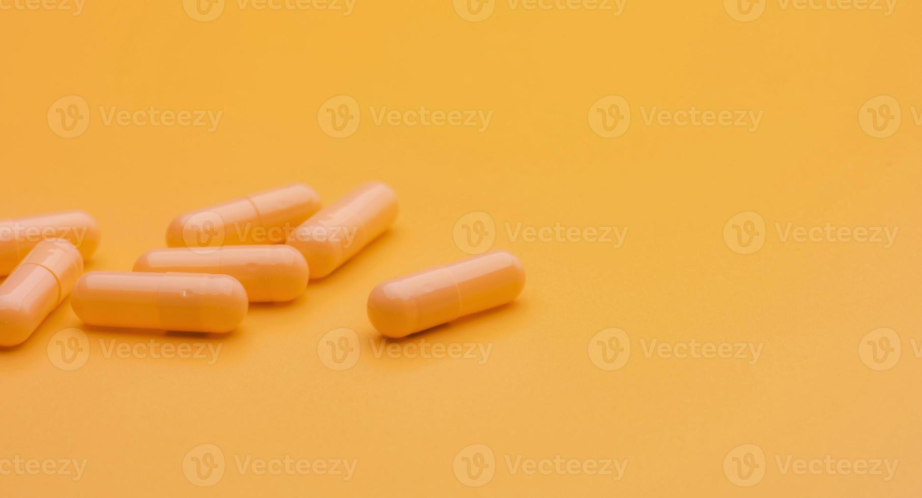 pastillas de cápsula amarilla sobre fondo amarillo con espacio de copia. concepto de farmacia y seguro de salud. medicamentos con receta. industria farmacéutica. vitaminas y suplementos. marketing para empresa de farmacia. foto