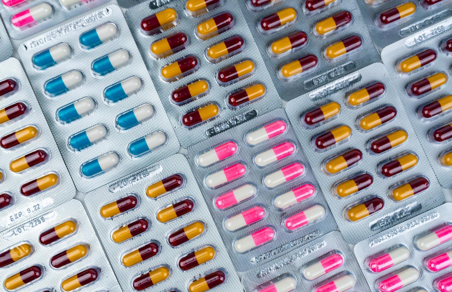 Top view of colorful antibiotic capsule pills in blister pack. Antibiotic drug resistance. Pharmaceutical industry. Pharmacy drug store background. Global health care.  Antimicrobial capsule pills. photo