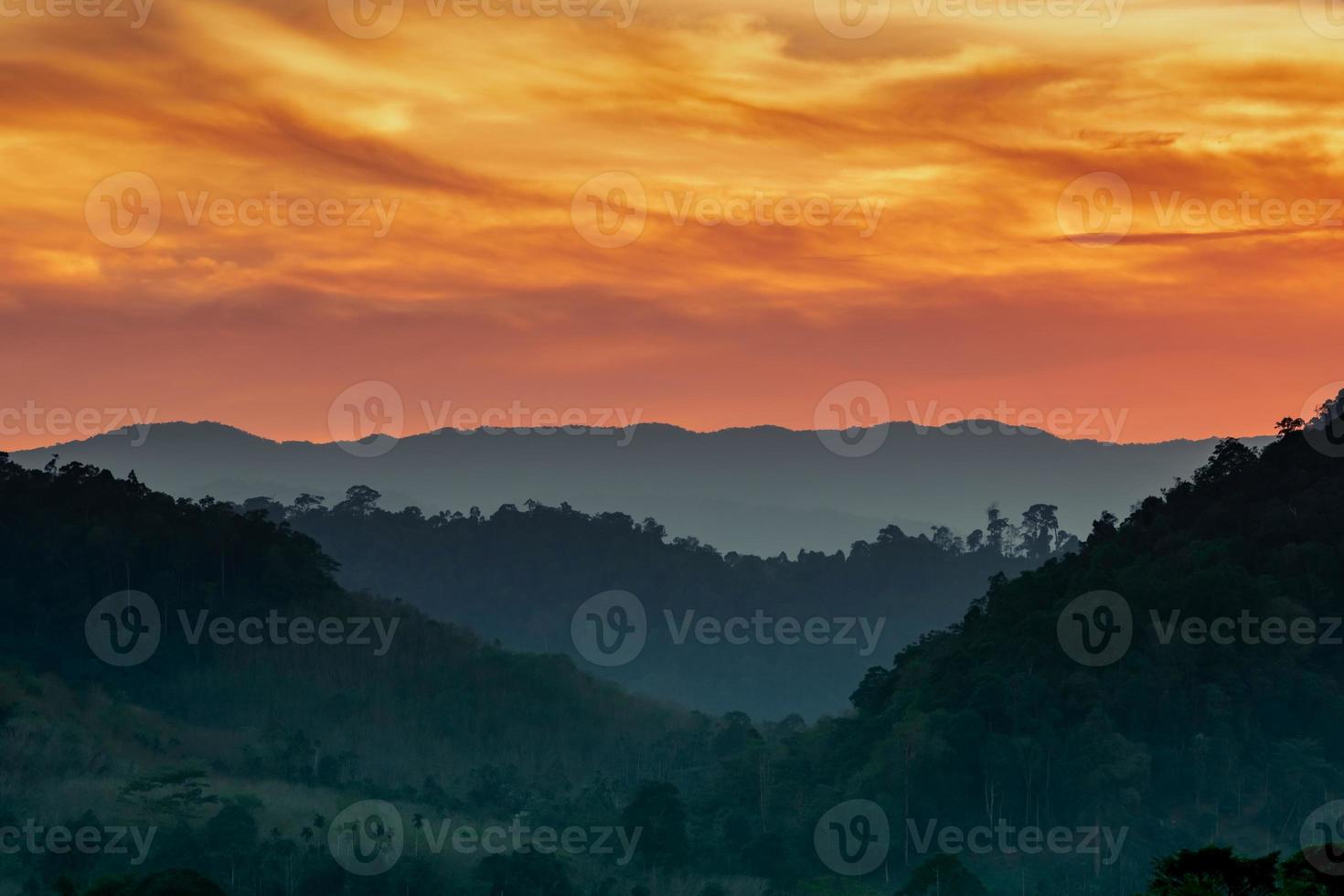 Beautiful nature landscape of mountain range with sunset sky and clouds. Mountain valley in Thailand. Scenery of mountain layer at dusk. Tropical forest. Natural background. Orange and golden sky. photo