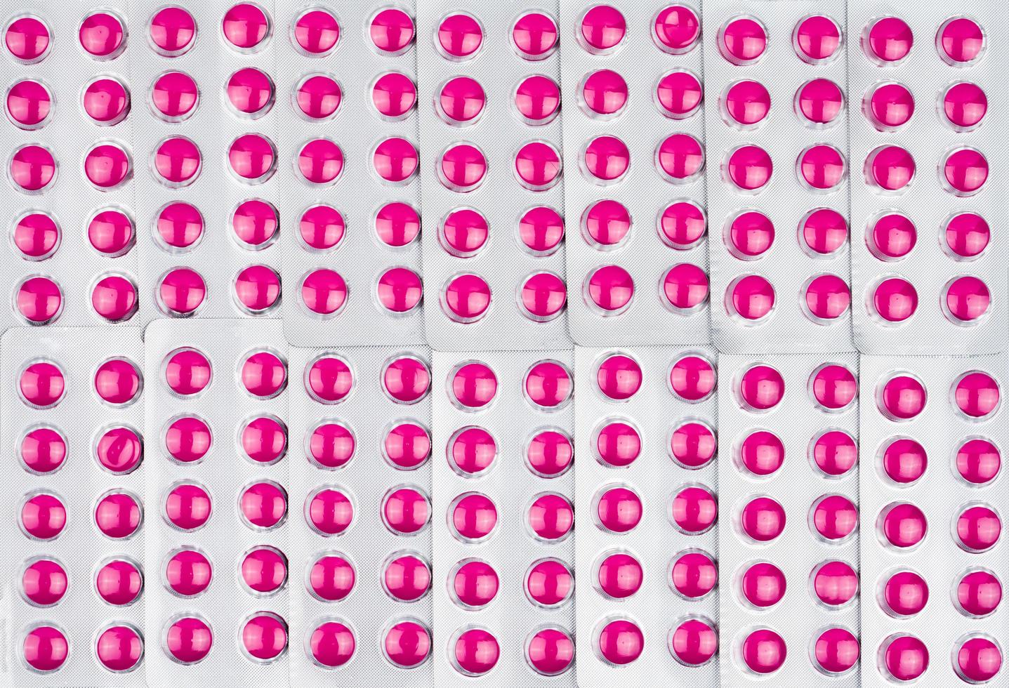 marco completo de pastillas rosadas redondas en blisters. uso de patrón de píldoras rosas para papel tapiz de amor. Pastillas de ibuprofeno para aliviar el dolor, fiebre alta, dolor de cabeza, dolor de muelas e inflamación de heridas foto