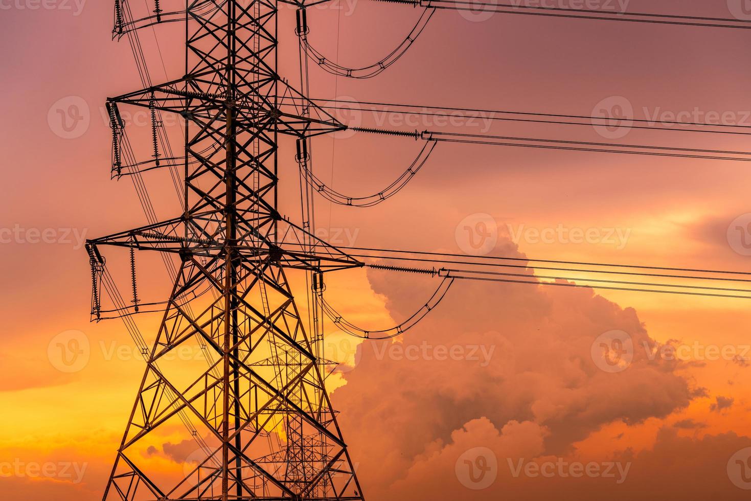 High voltage electric pylon and electrical wire with sunset sky. Electricity pole. Power and energy concept. High voltage grid tower with wire cable. Beautiful golden sunset sky and fluffy clouds. photo