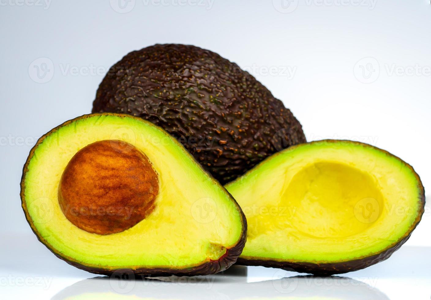 Avocado with seed isolated on white background. Source of omega 3 from natural food. Healthy food for baby. Half pieces of avocados arranged with beautiful pattern. Organic food for vegetarian. photo