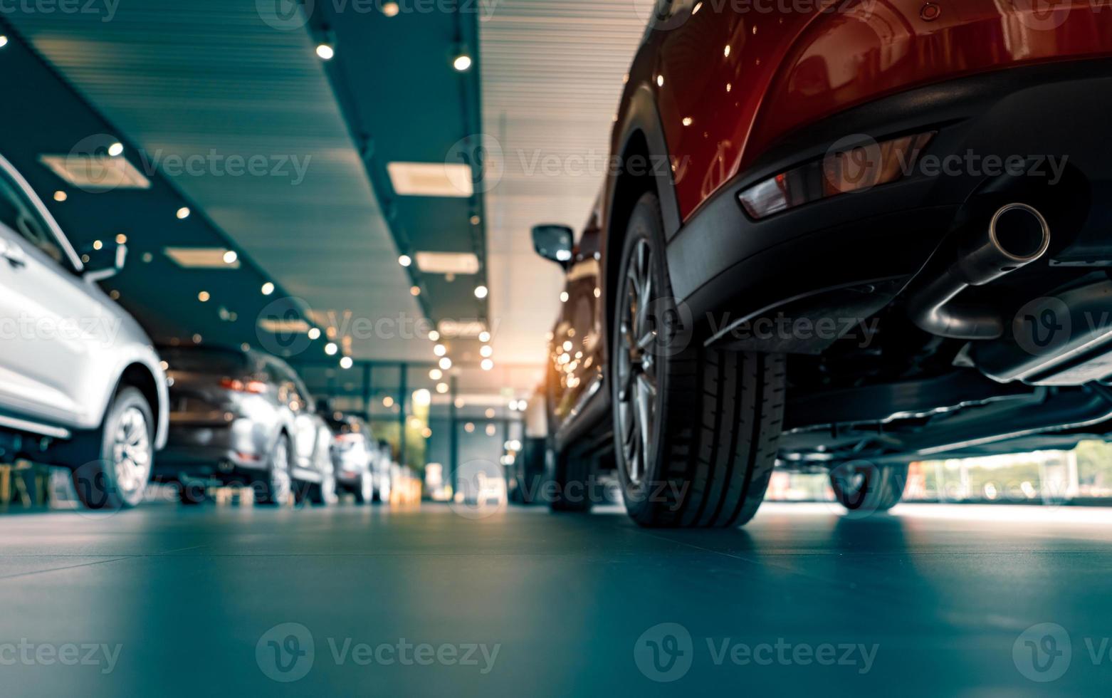 Rearview car parked in luxury showroom. Car dealership office. New car parked in modern showroom. Car for sale and rent business concept. Automobile leasing and insurance concept. Electric automobile. photo