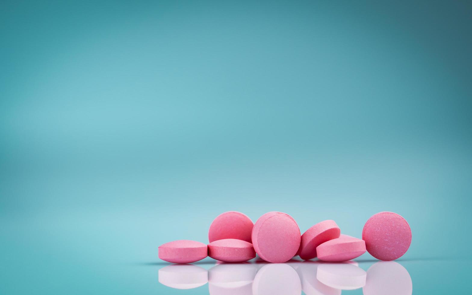 Pastillas redondas rosadas con sombra sobre fondo degradado. industria farmacéutica. productos de farmacia vitaminas y suplementos. uso de medicamentos en el hospital o farmacia. mercado minorista mundial de medicamentos. foto