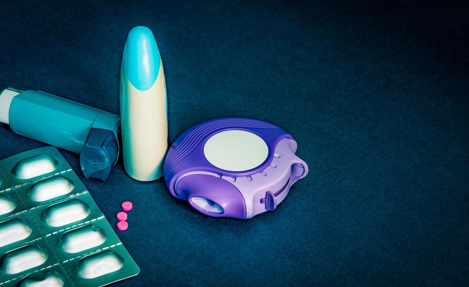 Set of asthma inhaler, accuhaler and anti-allergy pills for treatment asthma. Asthma controller, reliever equipment on blue table with copy space. Bronchodilator and steroids drug for severe asthma. photo