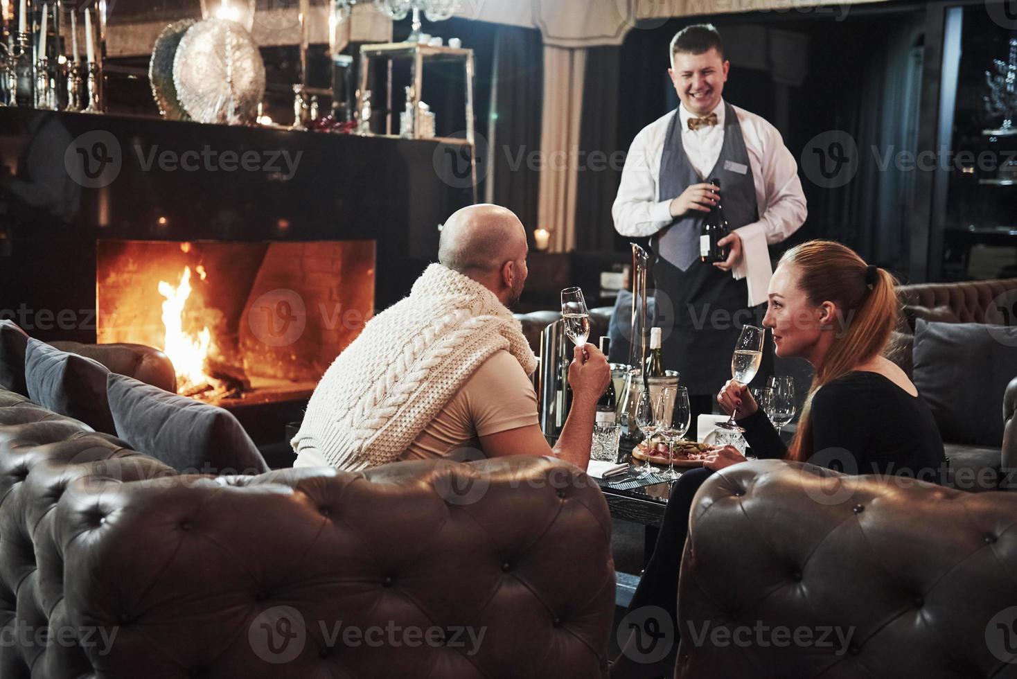 Laughing with waiter. Girl with her boyfriend have nice evening at beautiful restaurant photo