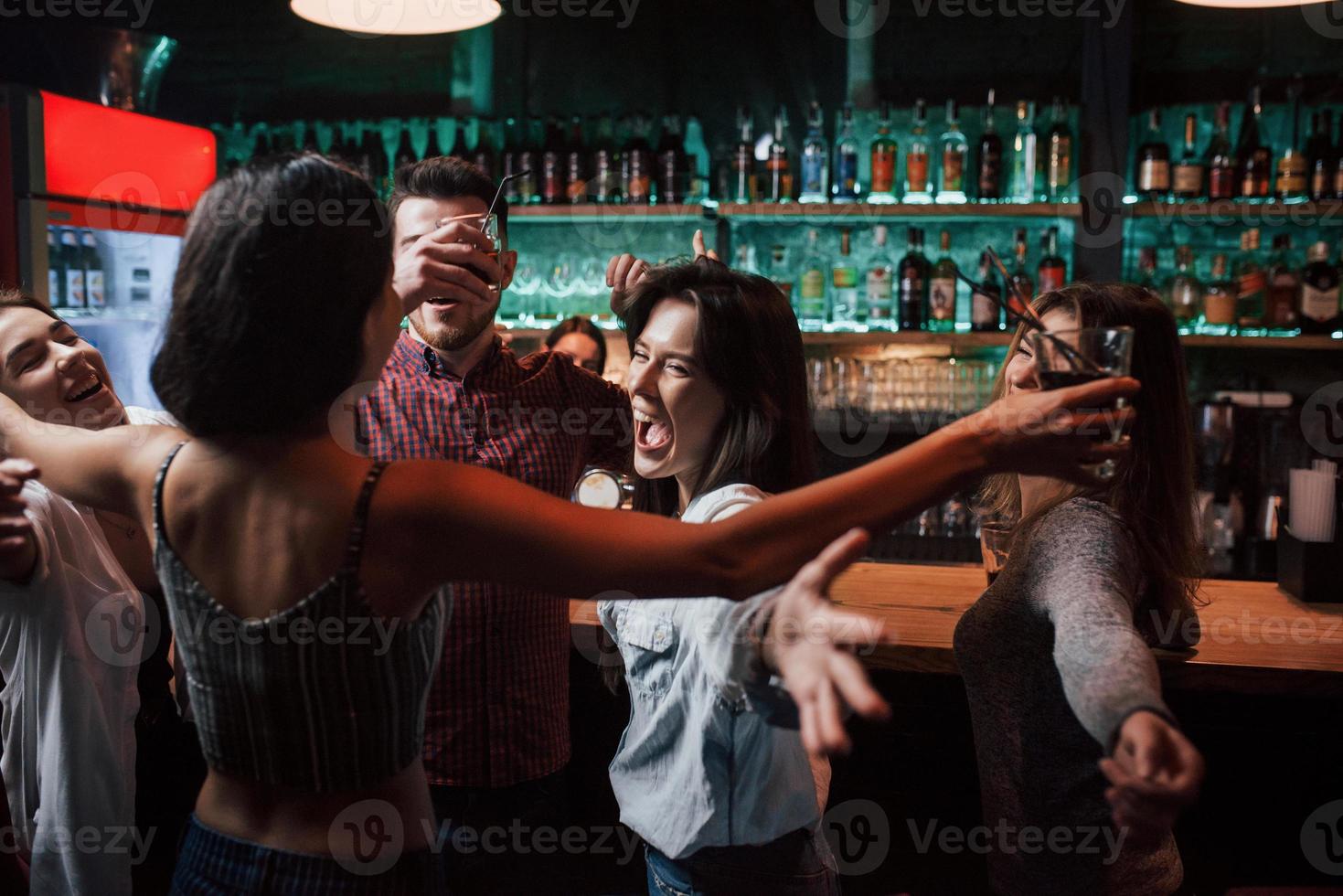 Wide hugs. Beautiful youth have party together with alcohol in the nightclub photo
