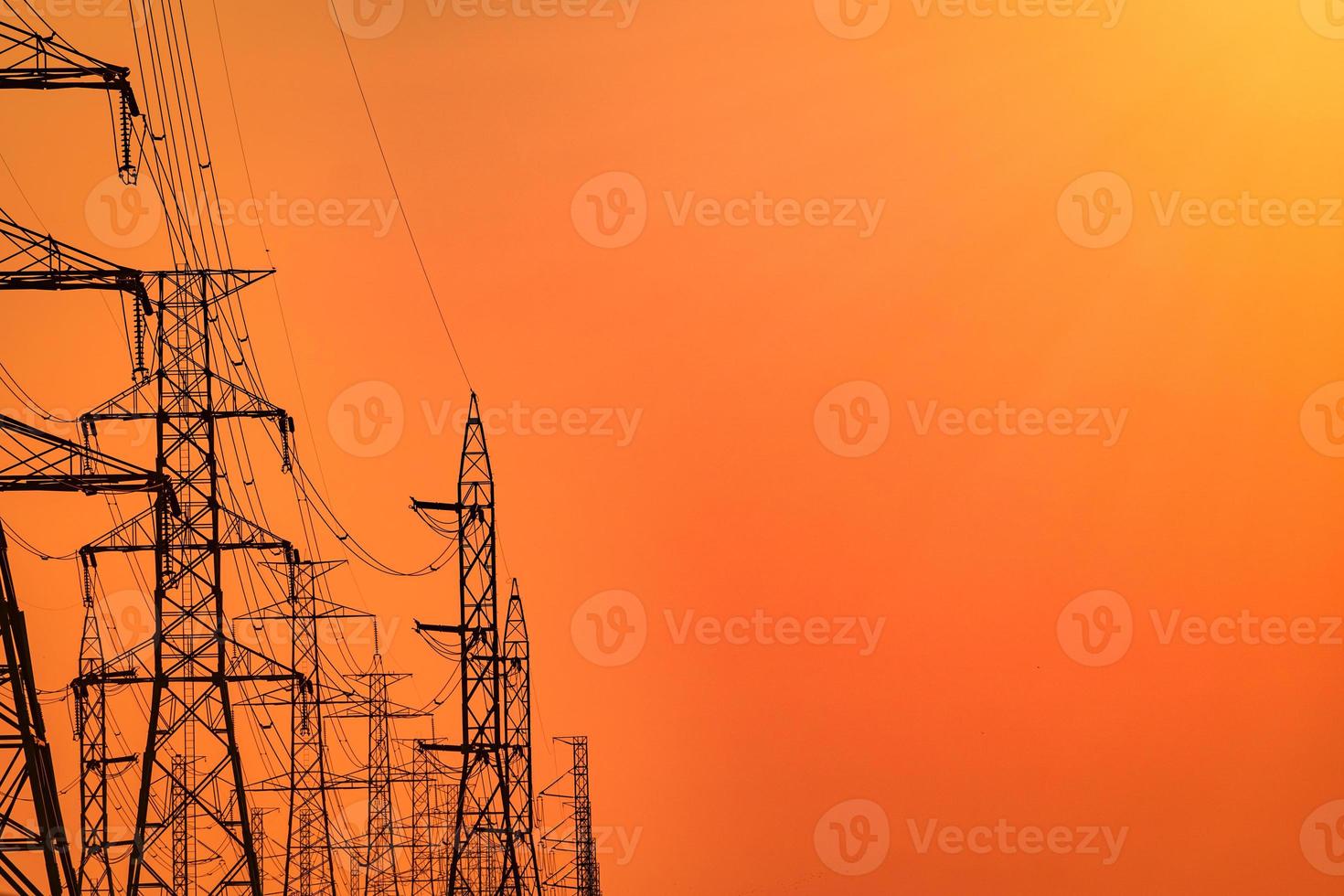 High voltage electric pole and transmission lines in the evening. Electricity pylons at sunset. Power and energy. Energy conservation. High voltage grid tower with wire cable at distribution station. photo