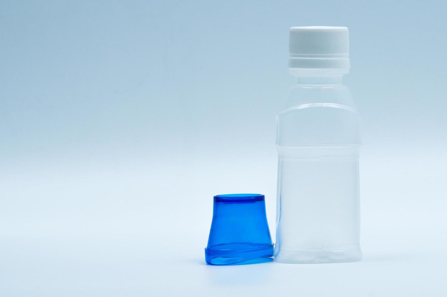 loción ocular estéril en botella de plástico blanco con baño de ojos azul y espacio de copia y etiqueta en blanco. lavado de ojos después de la contaminación del contacto con el medio ambiente o después de nadar en una piscina contaminada con cloro. foto