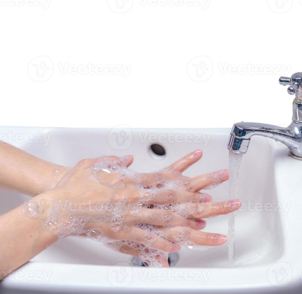 Woman washing hand with soap foam and tap water in bathroom. Hand clean under faucet on sink for personal hygiene to prevent flu and coronavirus. Good procedure of hand wash to kill bacteria, virus. photo
