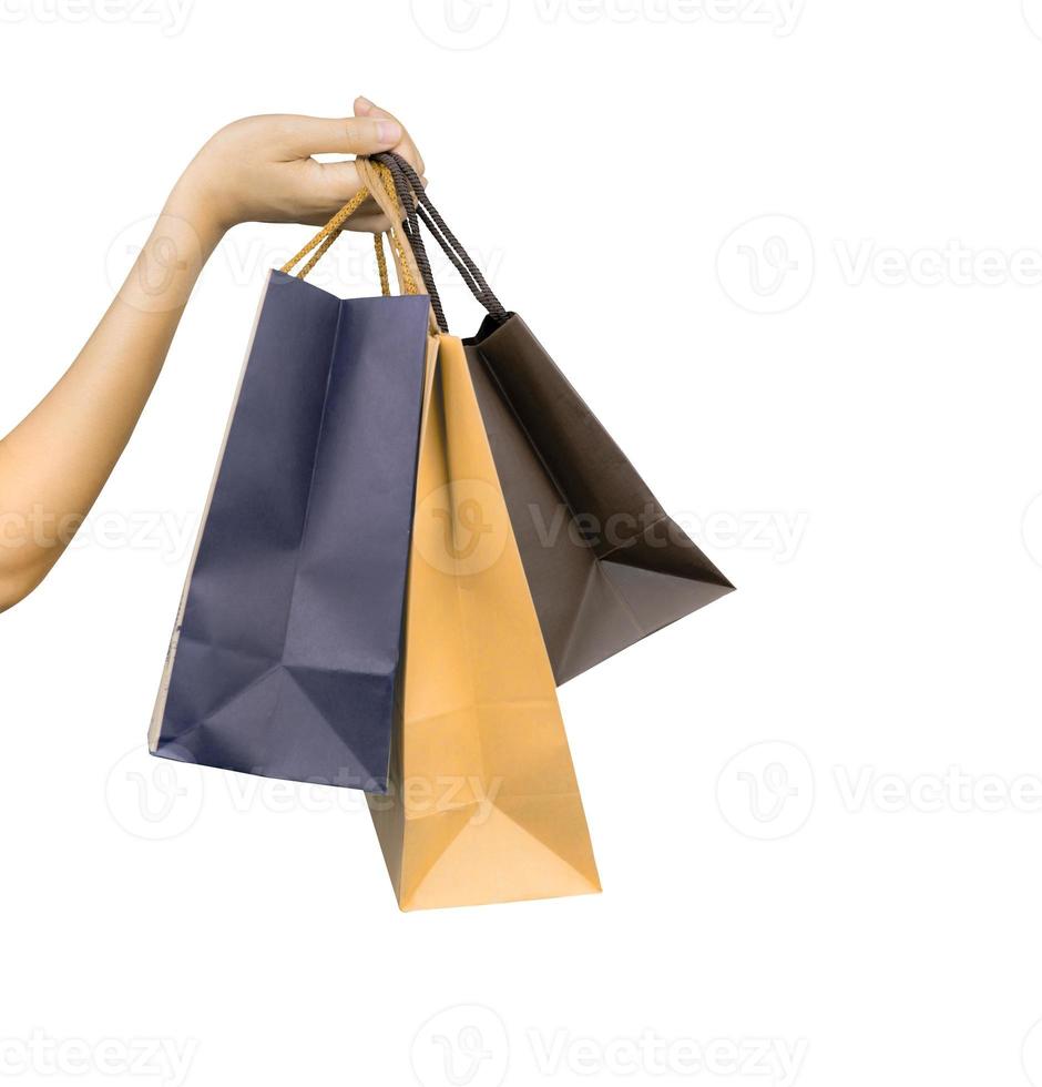 Woman carrying paper shopping bags isolated on white background. Adult woman hand hold three shopping bag with blue and brown color. Customer and shopping bag. Black Friday concept. Consumerism. photo