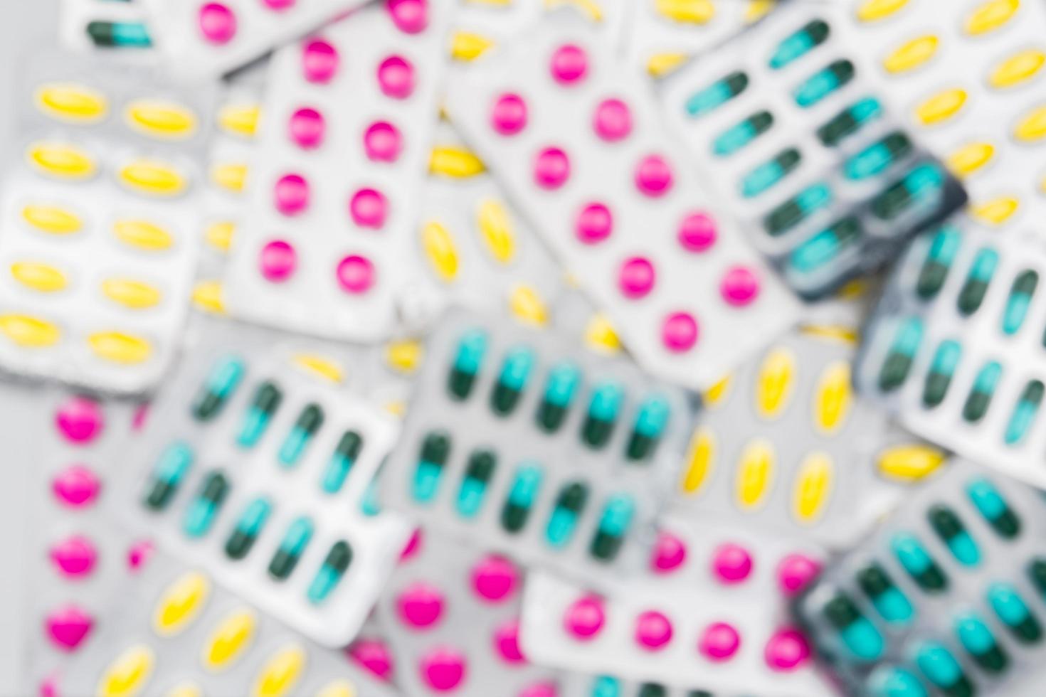 Blurred background of colorful pile of pills in blister packs. Drug use with reasonable concept. Global healthcare wallpaper. photo