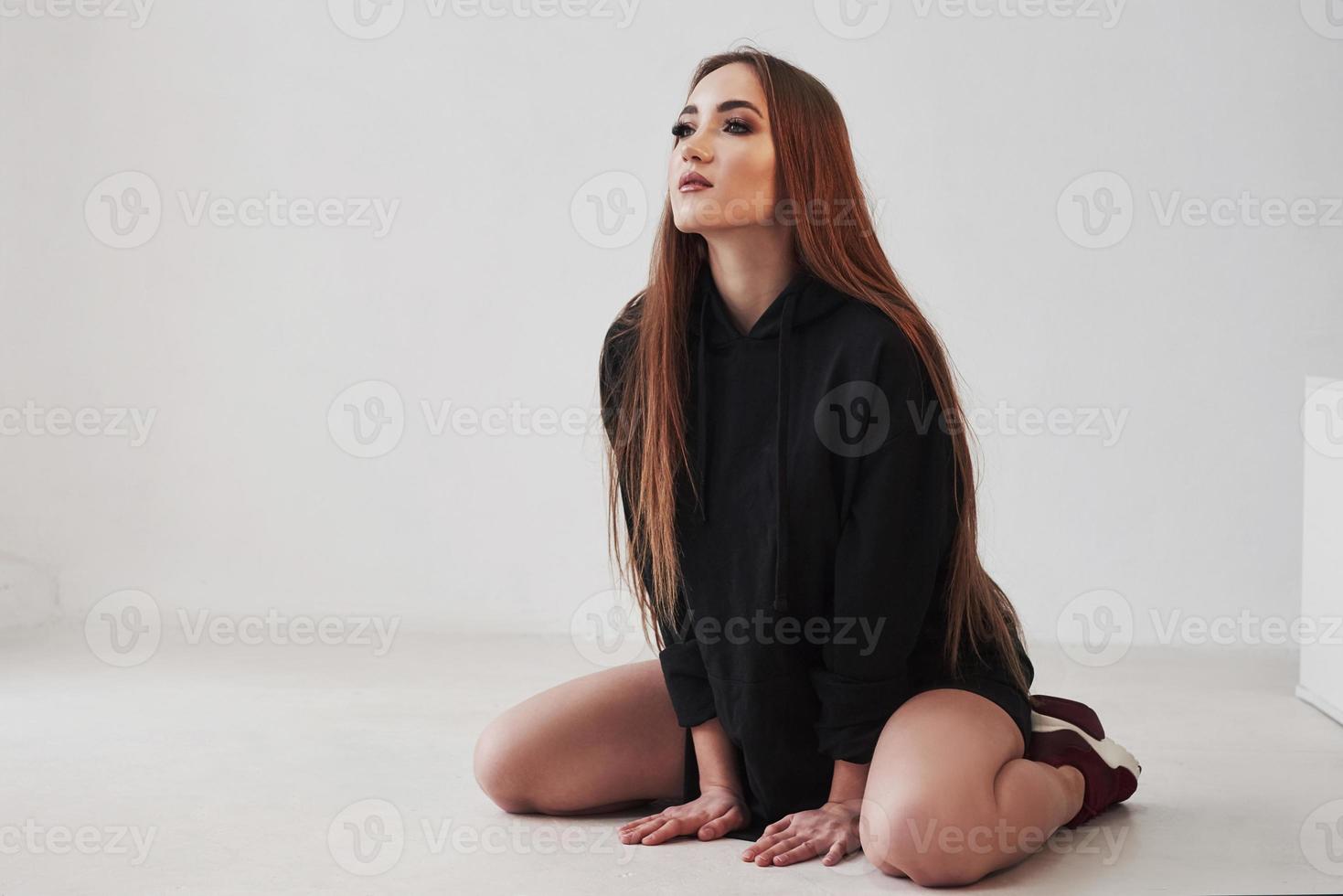 In black wear. Portrait of seductive brunette in the studio with white background photo