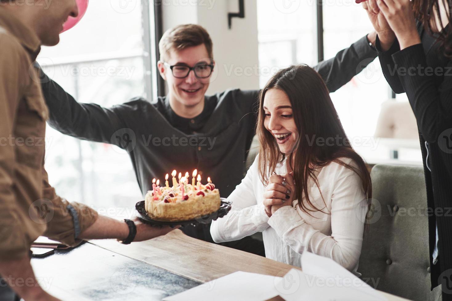 ella ama a sus compañeros. uno de los empleados tiene cumpleaños hoy. compañeros de trabajo amistosos decide hacer una sorpresa para ella foto