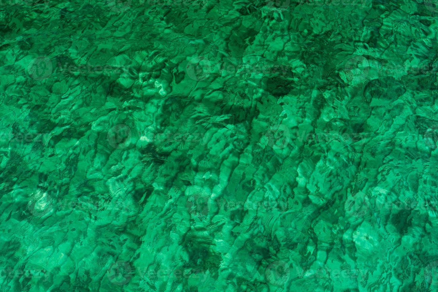 Fondo de textura abstracta verde de agua de mar verde esmeralda. vista superior del agua de mar verde con un patrón único. fondo verde superficie de onda de agua de mar en la costa. agua turquesa en mar poco profundo. foto