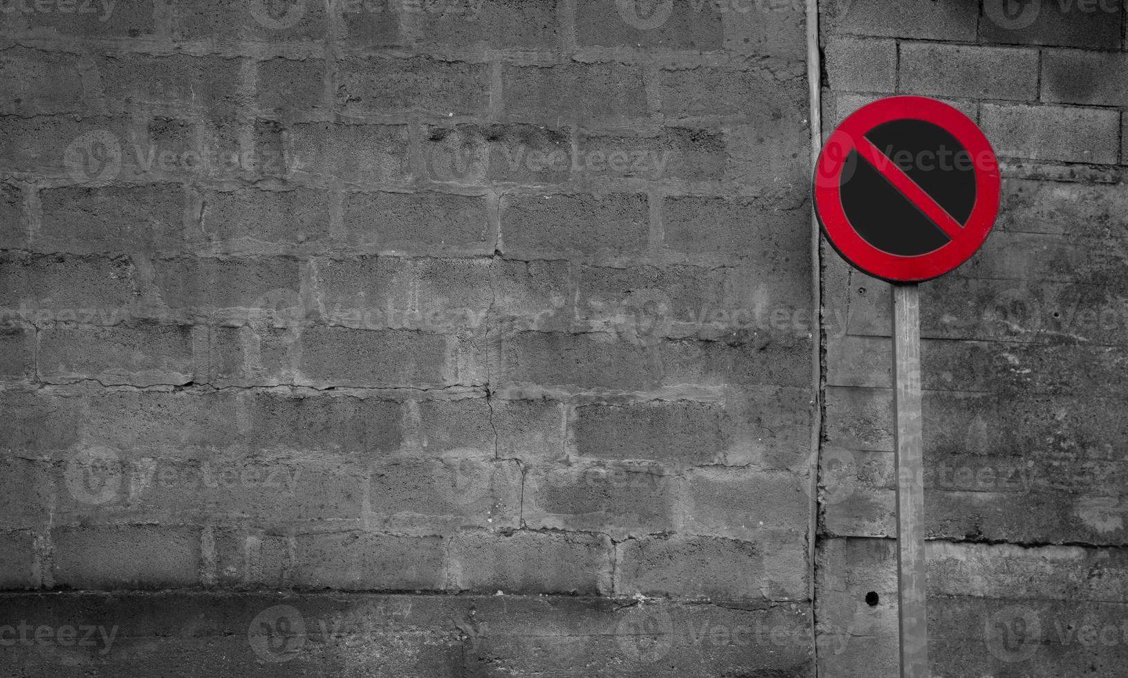 No parking sign. Regulatory sign. Circle red and black no parking sign on post. Traffic sign on gray and white brick wall texture background. Road signs for prohibit car parking. Restrictive signs. photo