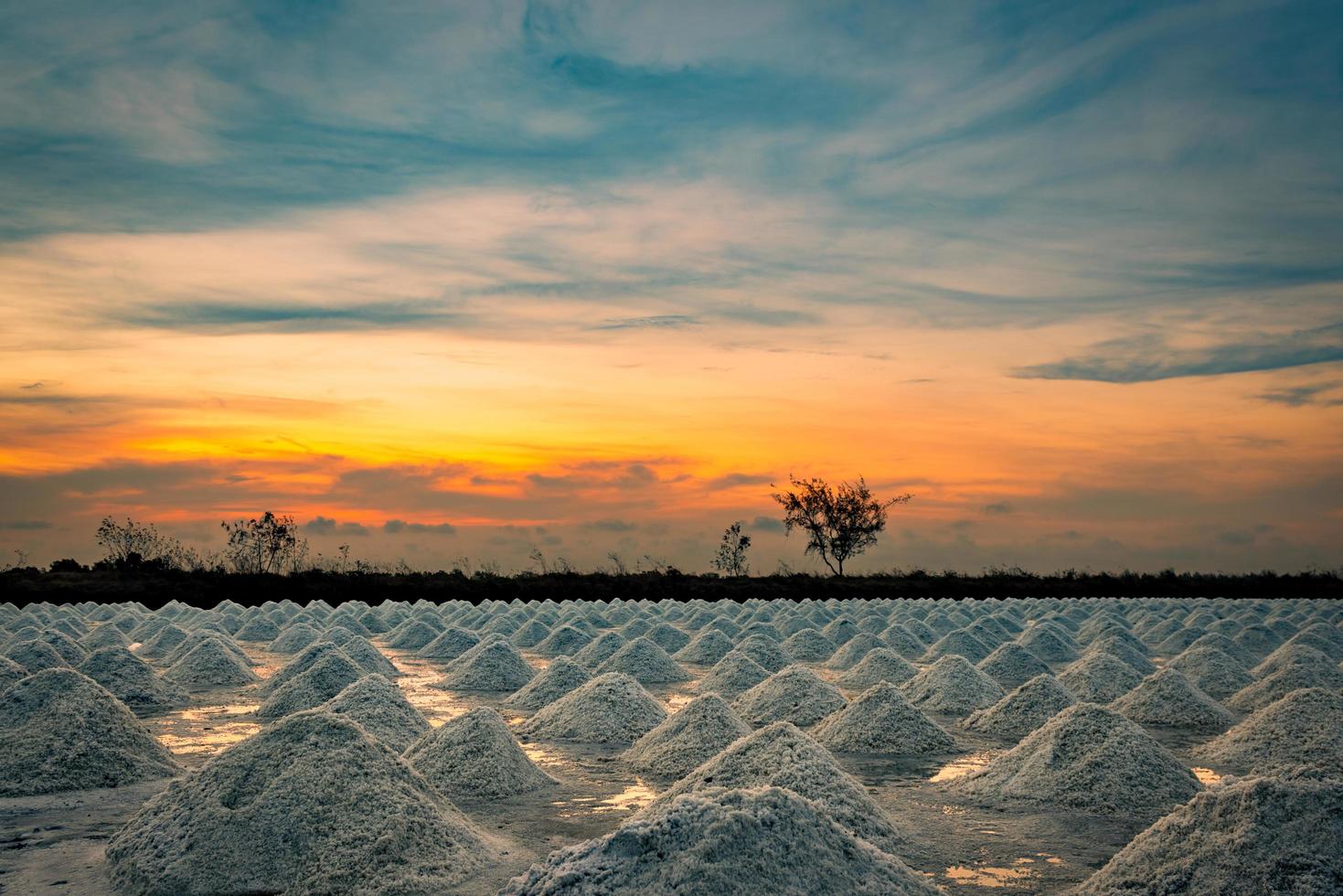 Salt farm in the morning with sunrise sky. Organic sea salt. Evaporation and crystallization of sea water. Raw material of salt industrial. Sodium Chloride. Solar evaporation system. Iodine salt. photo