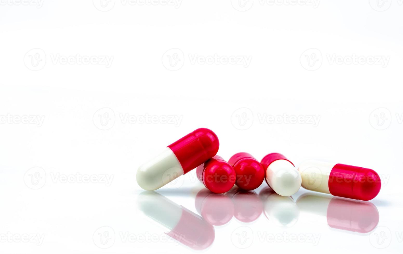 Red-white antibiotic capsule pill isolated on white background. Antibiotic drug resistance. Antimicrobial capsule pills. Pharmacy drugstore symbol. Pharmaceutical industry. Healthcare medication. photo