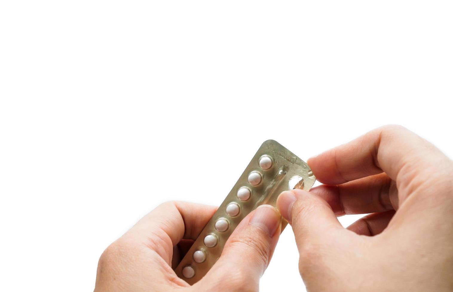 mano de mujer tomando pastillas anticonceptivas. mujer adulta asiática sosteniendo un paquete de píldoras anticonceptivas aisladas en fondo blanco con camino de recorte. elegir la planificación familiar con el concepto de píldora anticonceptiva foto