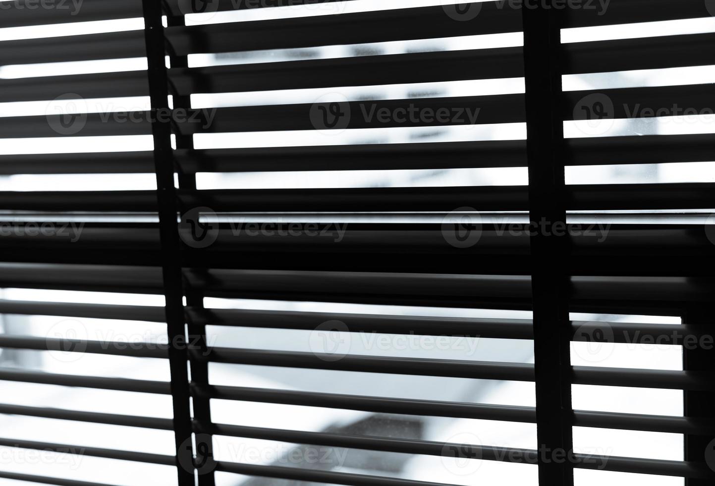 Opened venetian plastic blinds in black and white. Plastic window with blinds. Interior design of living room with window horizontal blinds. Window slatted shades made of plastic. Hopeless and despair photo