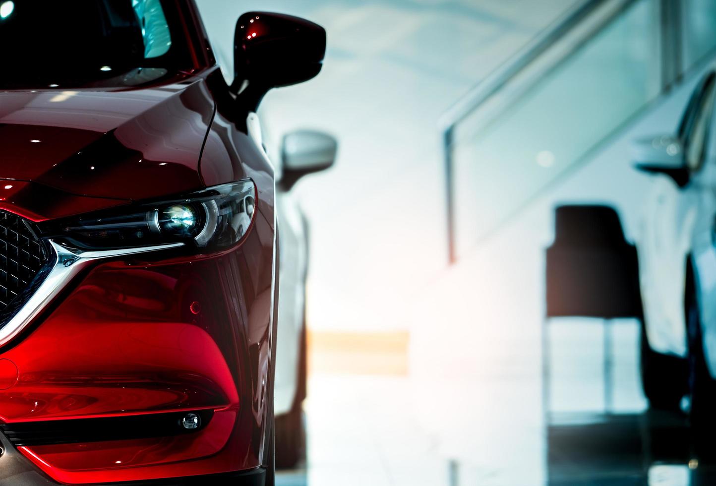 vista frontal del coche rojo. nuevo coche compacto de lujo aparcado en una moderna sala de exposición a la venta. oficina del concesionario de automóviles. tienda al por menor de automóviles. tecnología de coches eléctricos y concepto de negocio. alquiler de automóviles. foto