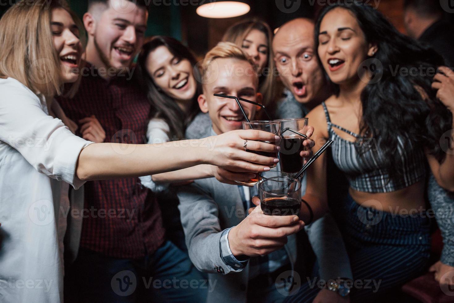 Imagine if every day will be a weekend. Group of young friends smiling and making a toast in the nightclub photo