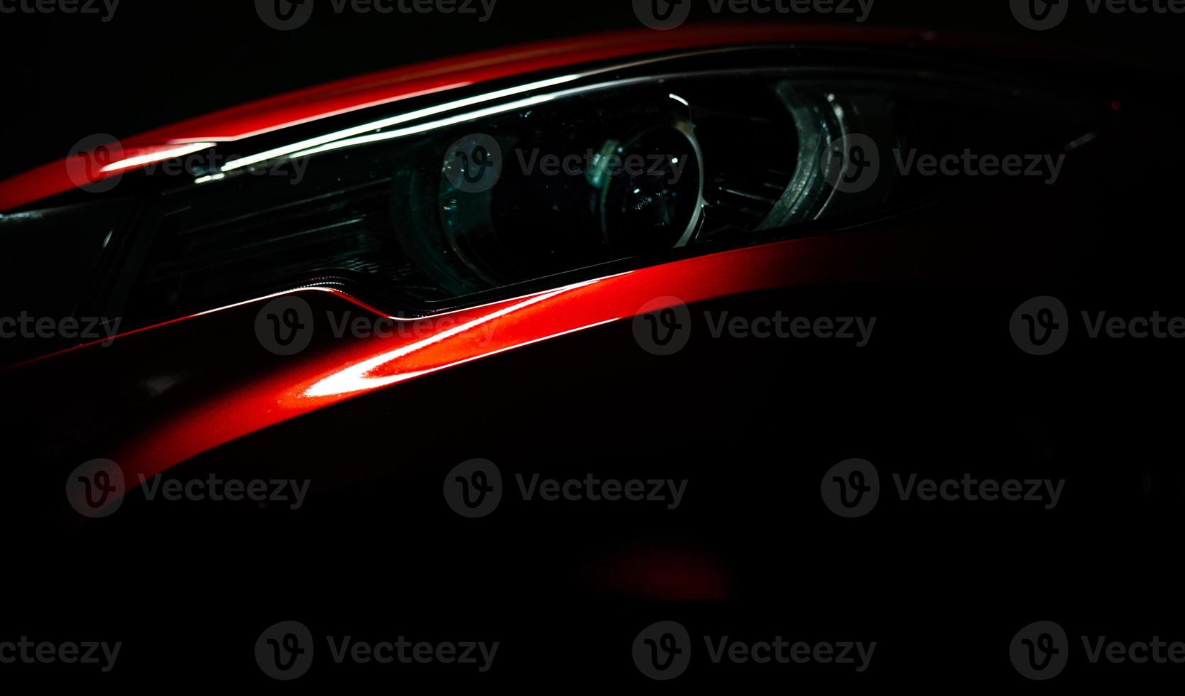 Closeup headlight of shiny red luxury SUV compact car. Elegant electric car technology and business concept. Hybrid auto and automotive concept. Car parked in showroom or motor show. Car dealership. photo
