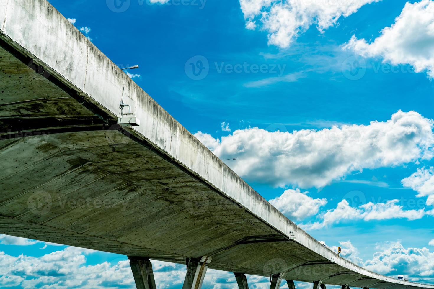 Bottom view of elevated concrete highway. Overpass concrete road. Road flyover structure. Modern motorway. Transportation infrastructure. Concrete bridge engineering construction. Bridge architecture. photo