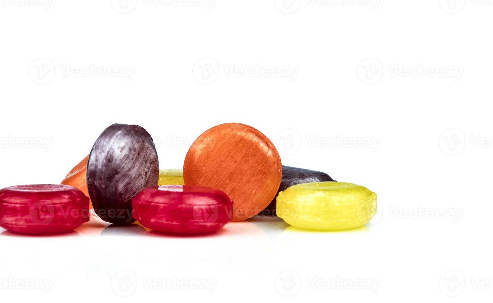 Medical lozenges for relief cough, sore throat and throat irritation isolated on white background. Cough and colds drop. Colorful cough pastille. Red, orange, yellow, and purple round candy or sweets. photo