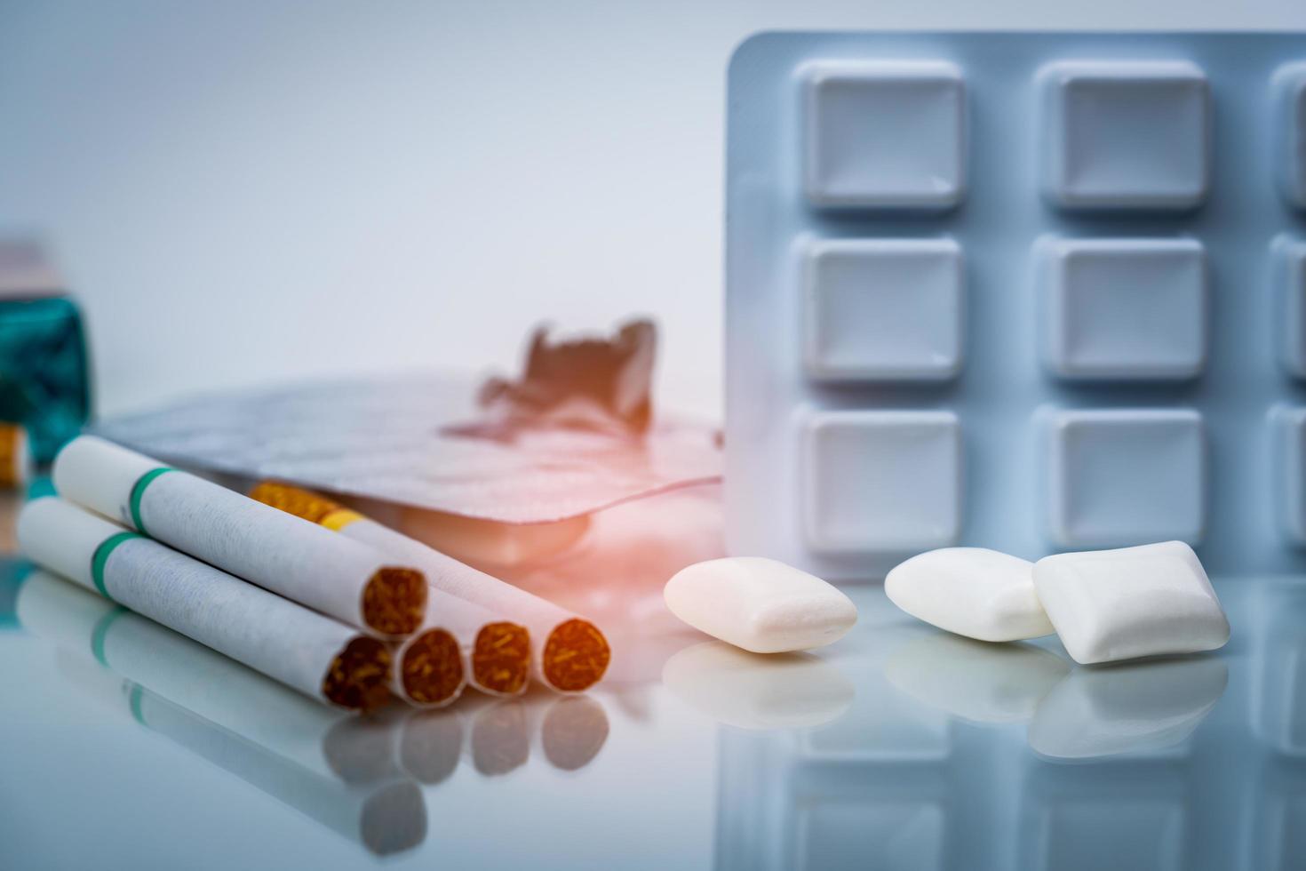 Nicotine chewing gum in blister pack near pile of cigarette. Quit smoking or smoking cessation and lung cancer concept. 31 May World no tobacco day. photo