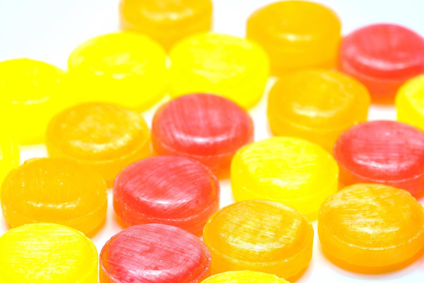 Medical lozenges for relief cough, sore throat and throat irritation isolated on white background. Cough and colds drop. Colorful cough pastille. Red, orange, and yellow round candy or sweets. photo