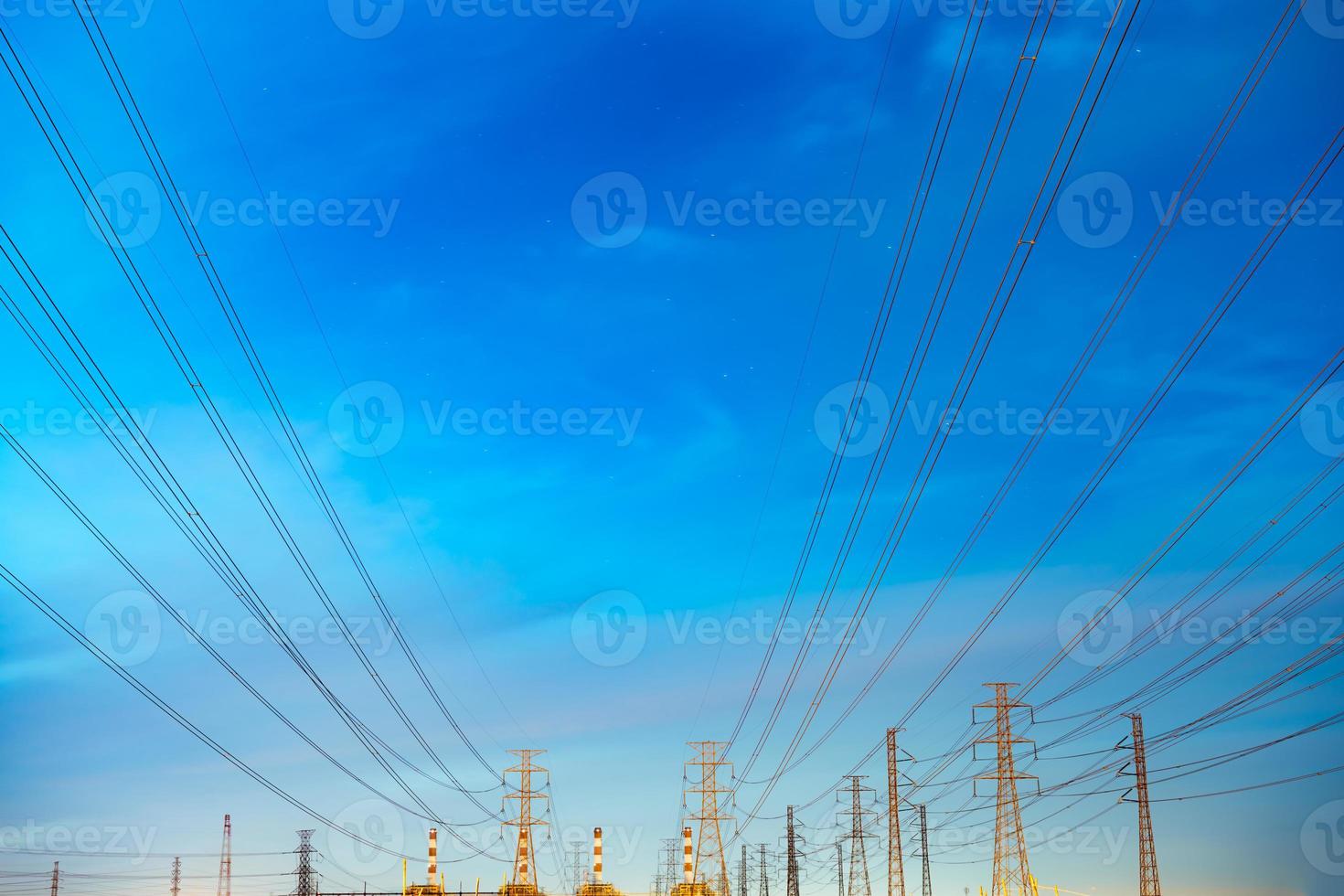 High voltage electric pole and transmission lines in the evening. Electricity pylons at night. Power and energy. Energy conservation. High voltage grid tower with wire cable at distribution station. photo