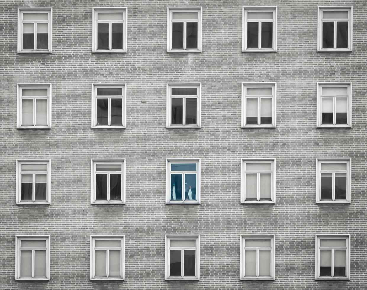 Glass window of skyscraper apartment or hotel building. Exterior brick wall of residential building. Architecture design. Window of building texture background. Gray and white vintage building. photo