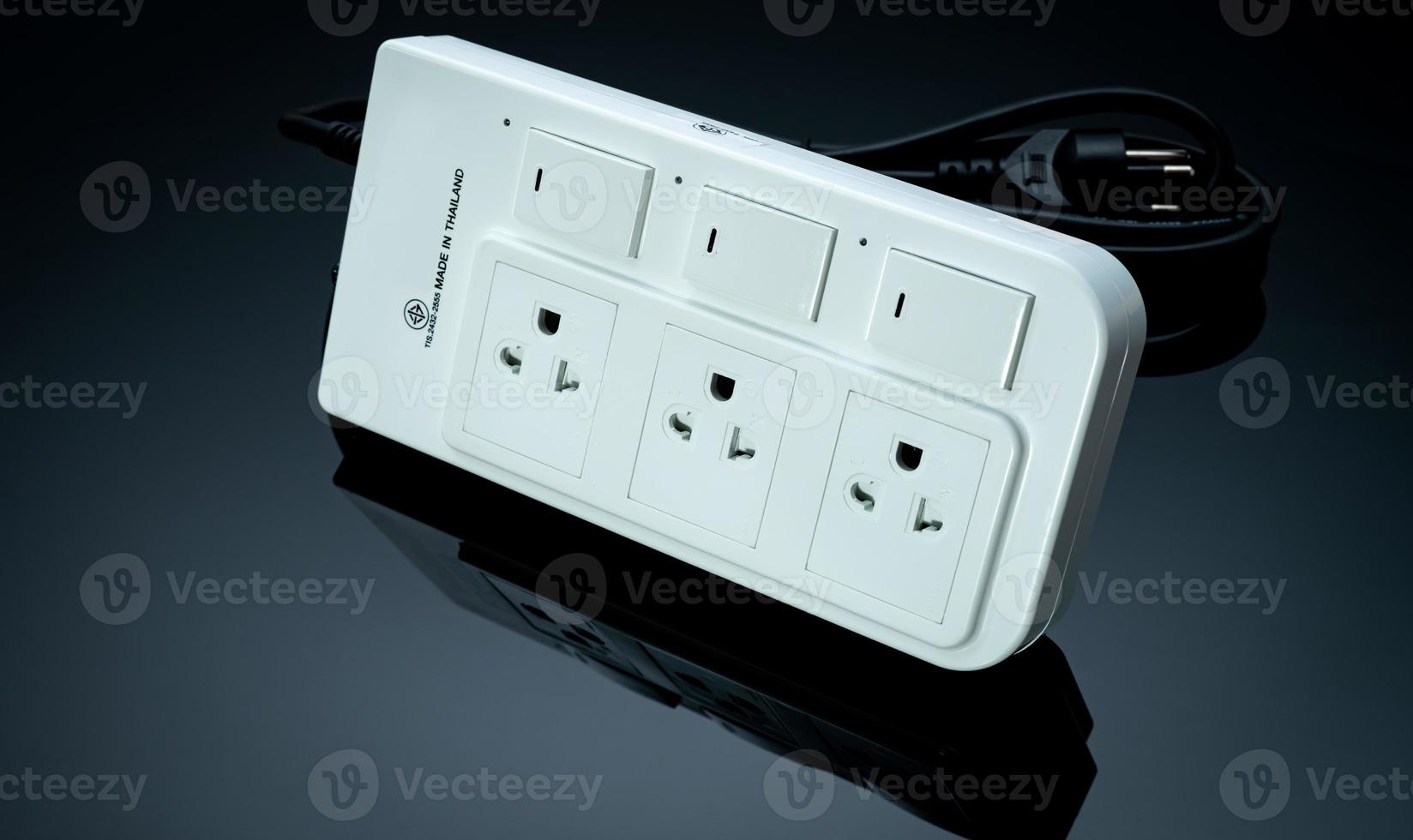 Power strip with three electrical standard socket on black background. White universal plug with overload protection. Fire resistant material for cover. Circuit breaker. Individual switch. Power plug. photo