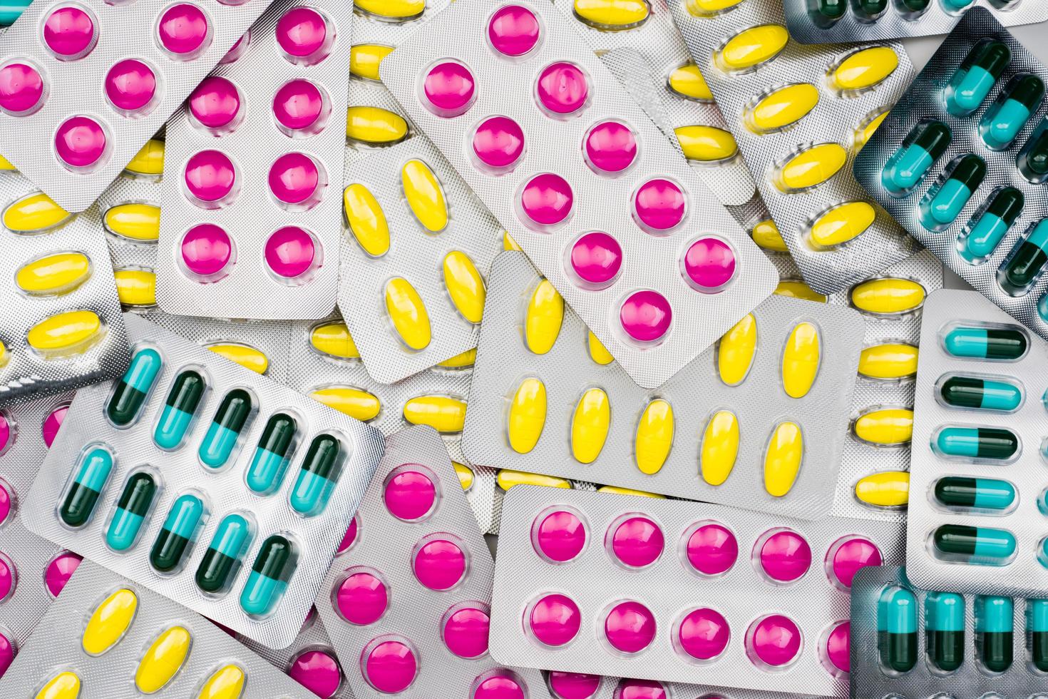 Top view of colorful pile of pills in blister packs. Drug use with reasonable concept. Global healthcare wallpaper. photo