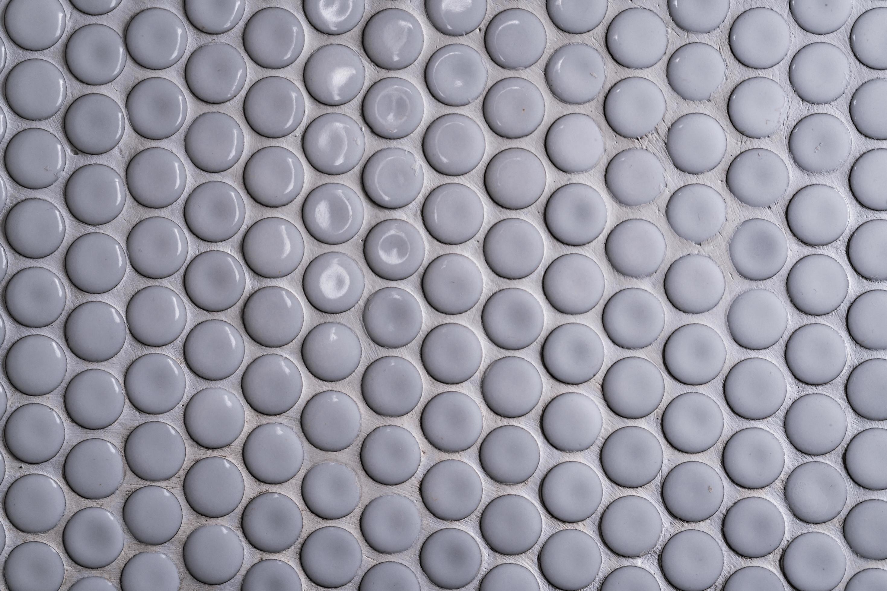 White ceramic tile wall with many small round unique pattern. Top view