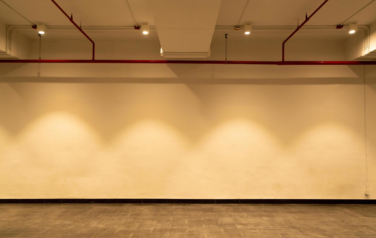 Empty room and white wall with spotlights. Illuminated lamp light. Room interior with ceiling lamp light and colorful wall. Empty tile floor photo