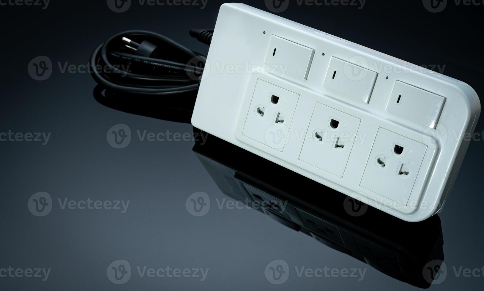 Power strip with three electrical standard socket on black background. White universal plug with overload protection. Fire resistant material for cover. Circuit breaker. Individual switch. Power plug. photo