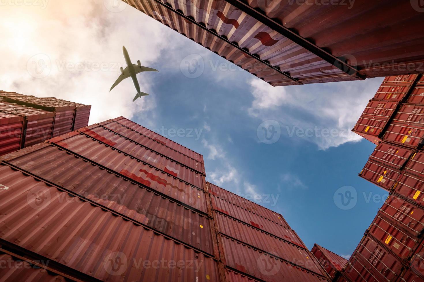 Airplane flying above container logistic. Cargo and shipping business. Container ship for import and export logistic. Logistic industry from port to port. Container at harbor for truck transport. photo