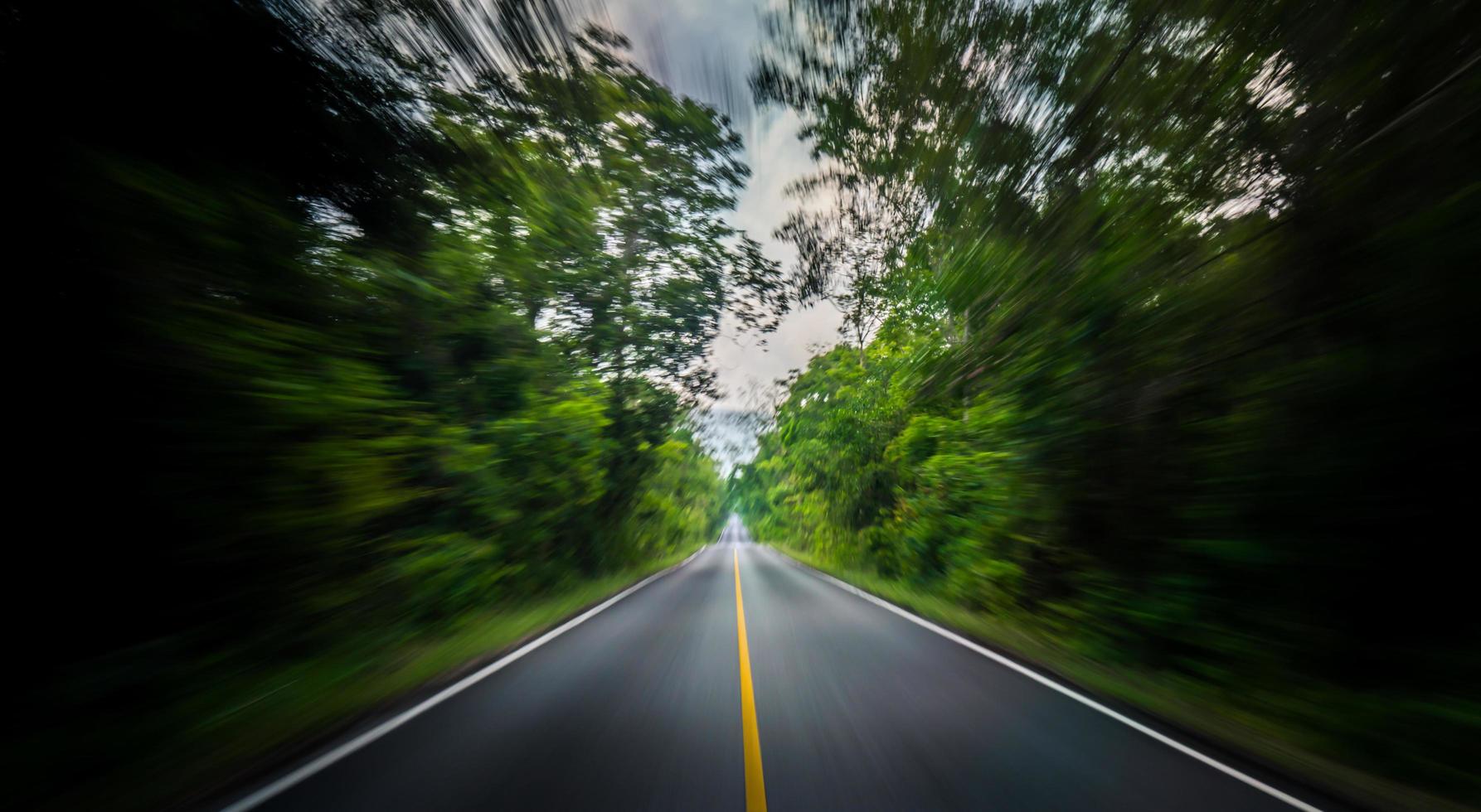 Empty asphalt road and speed motion blur on highway in summer with green trees forest at countryside photo