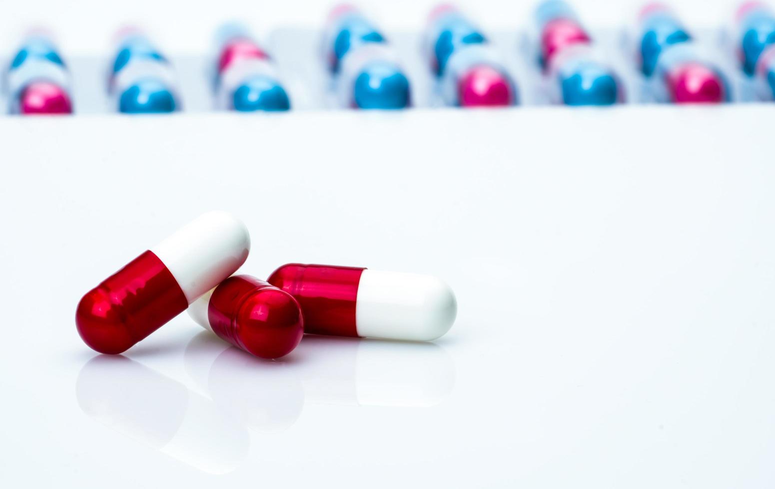 Red-white antibiotic capsule pills on pills pack blurred background with copy space for text. Antibiotics drug resistance and antimicrobial drug use with reasonable concept. Global healthcare. photo