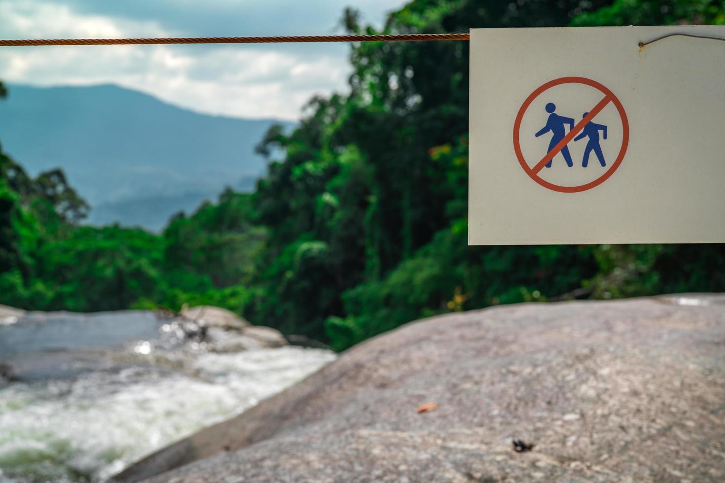 Do not walk of the trail. Warning sign in national park at waterfall in green tropical forest and mountain. Warning sign for traveler for prevent accident during trail. Sign for safety. photo