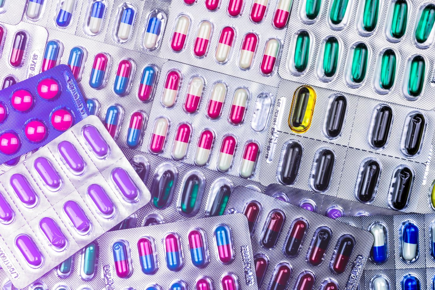 Top view of colorful tablets and capsule pills in blister packaging arrange with beautiful pattern. Pharmaceutical industry concept. Full frame pills background. Global pharmaceuticals. Defective. photo