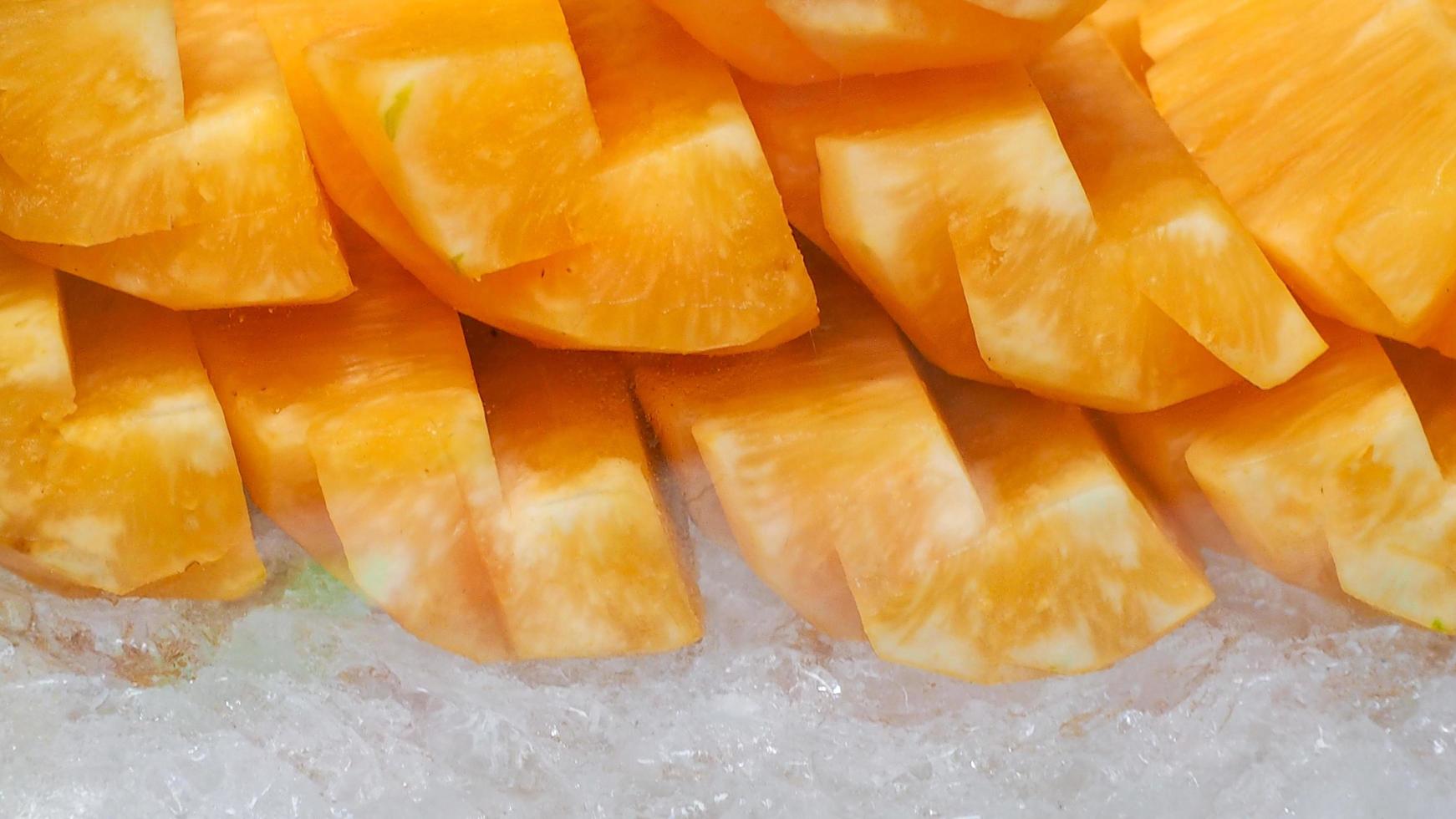 Orange or yellow pineapple sliced on crushed ice. Tropical fruit. Healthy snack. Bromelain enzyme extracted from pineapple. Source of nature enzyme helps digest proteins. Street food in Thailand. photo
