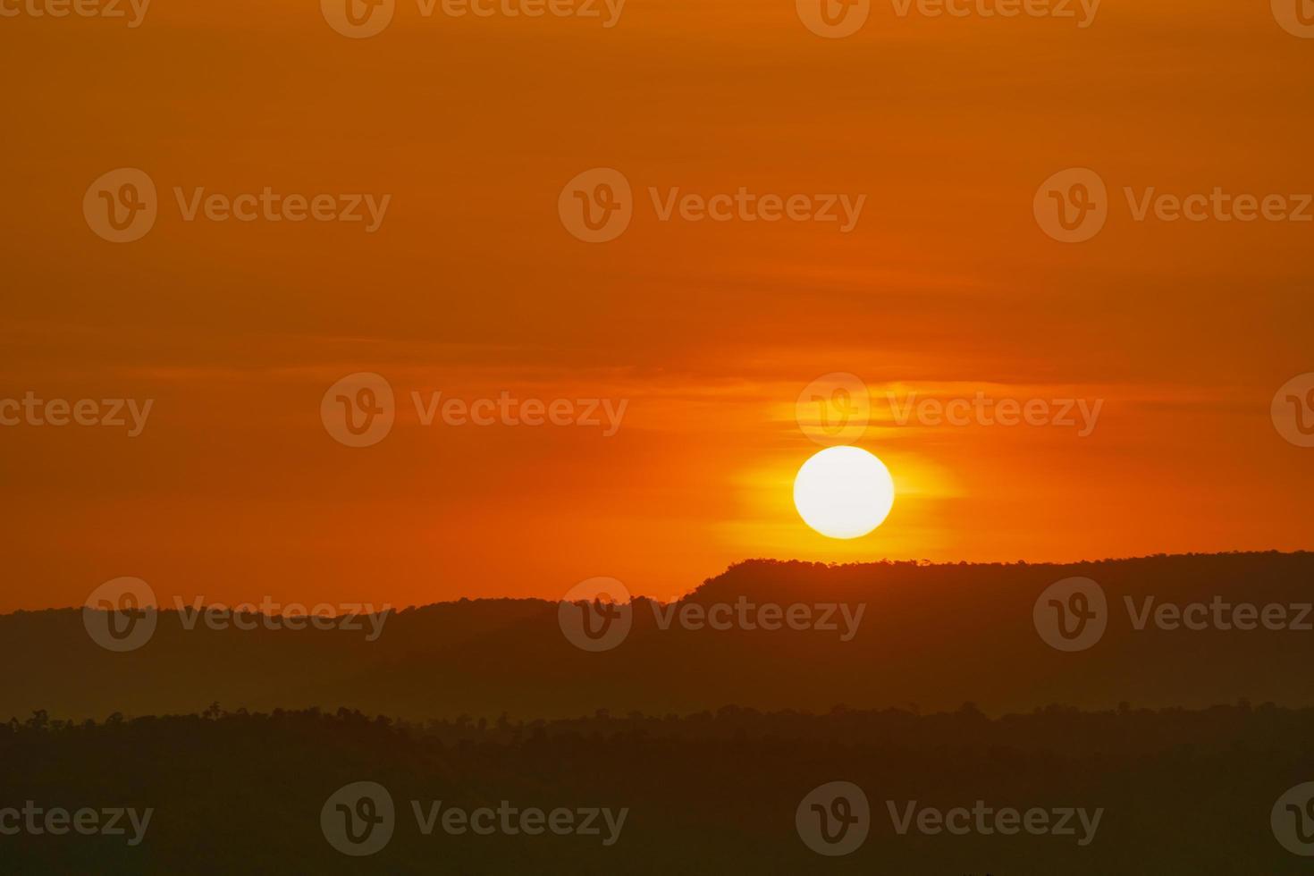 Beautiful nature landscape of mountain with sunset sky and clouds. Scenery of mountain layer at dusk with big round sun. Natural background. Orange and red sky in the evening. Sunset sky background. photo