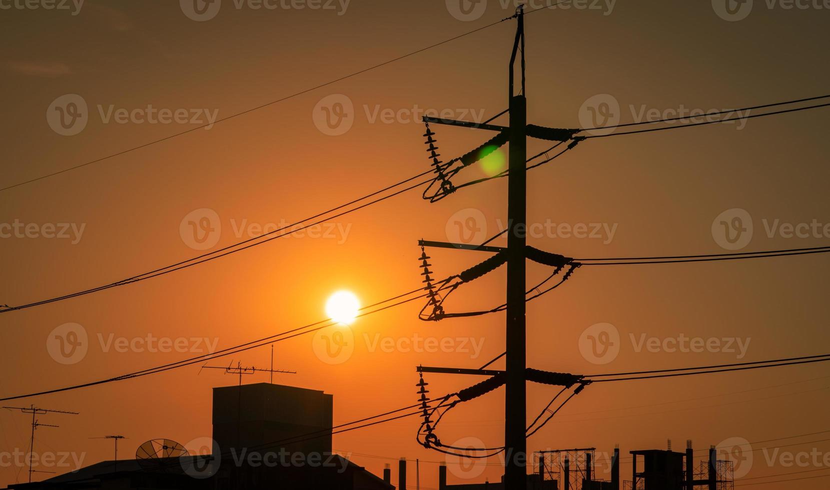 High voltage electric pole and transmission lines in the city. Electricity pylons at sunset. Power and energy. Energy conservation. High voltage tower with wire cable at distribution station. photo