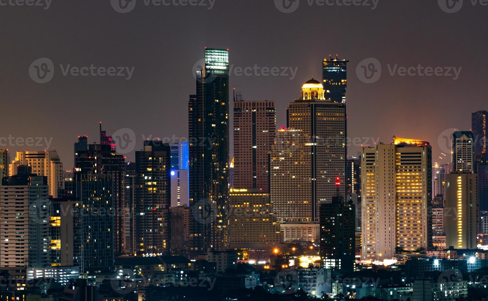 paisaje urbano de edificio moderno en la noche. edificio de oficinas de arquitectura moderna. rascacielos con hermoso cielo nocturno. edificio del centro financiero y de negocios. apartamento en la ciudad con luz nocturna. foto