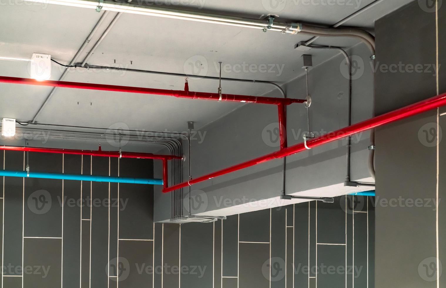 Automatic fire sprinkler safety system and red water supply pipe. Fire Suppression. Fire protection and detector. Fire sprinkler system with red pipe hanging from ceiling inside building. Wiring tube. photo