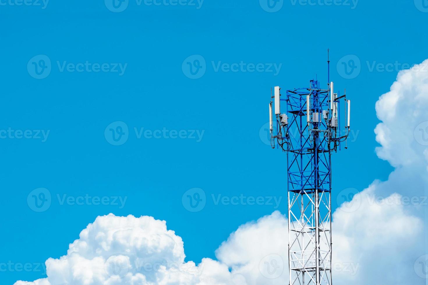 Telecommunication tower with blue sky and white clouds background. Antenna on blue sky. Radio and satellite pole. Communication technology. Telecommunication industry. Mobile or telecom 4g network. photo